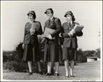 Three women in uniform holding papers