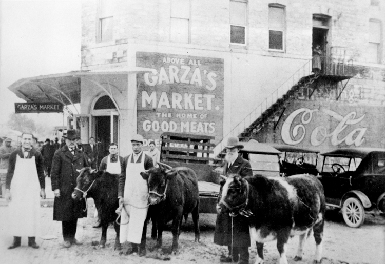 Ben Garza, shown in the center wearing an apron, started his meat market business in 1908 when he was nineteen years old.