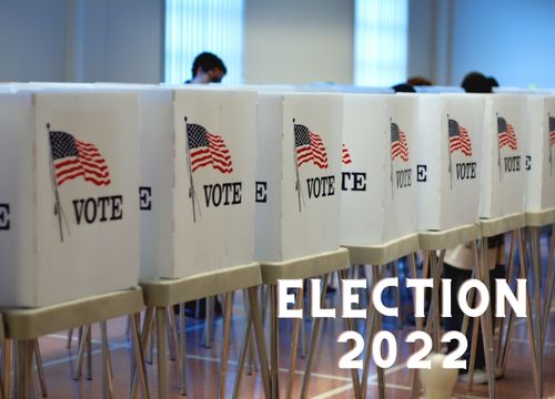 voting booths with american flags. Text that reads Election 2022.