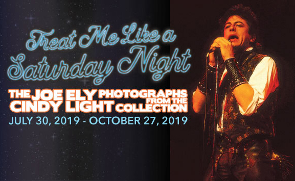 Man holding a microphone with the text Treat Me Like a Saturday Night: The Joe Ely Photographs from the Cindy Light Collection