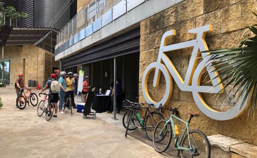 bikers lined up outside the Austin Public Library by a giant Bicycle sign