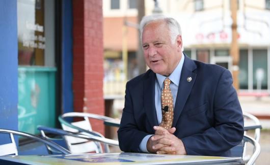 Austin Mayor Kirk Watson in blue suit with yellow tie 
