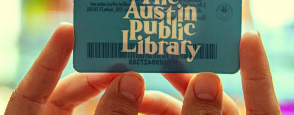 Hands holding up an Austin Public Library card 
