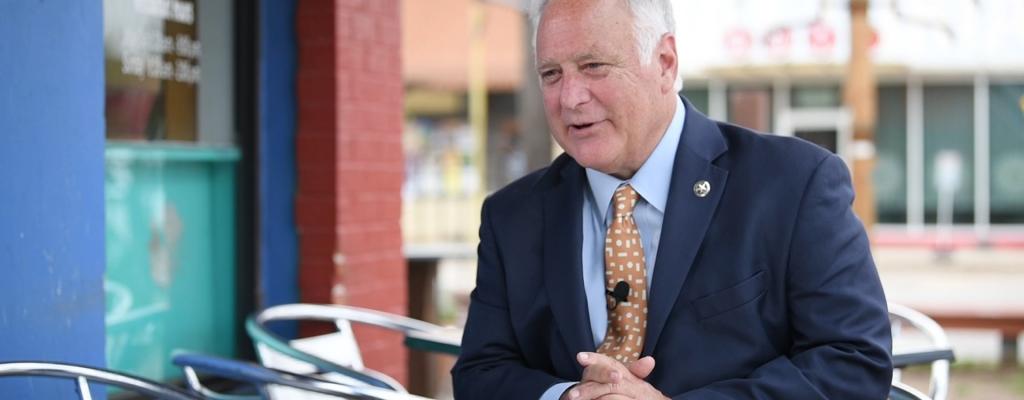 Austin Mayor Kirk Watson in blue suit with yellow tie 