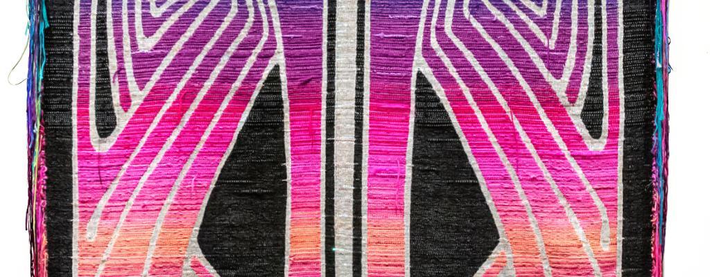 woven textile with bright pink and orange against black background