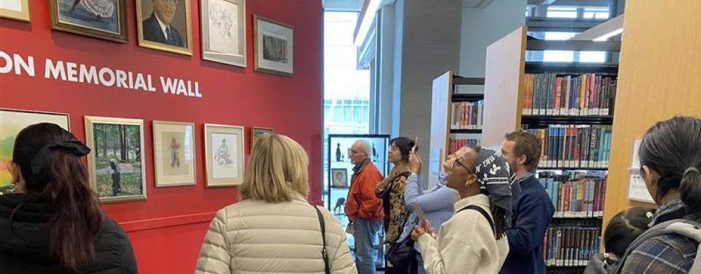 people gathered around looking at art on a wall
