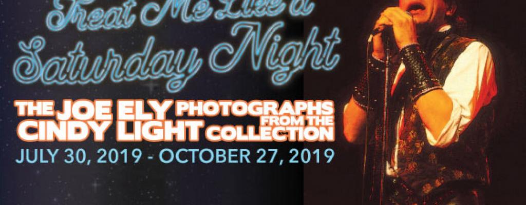 Man holding a microphone with the text Treat Me Like a Saturday Night: The Joe Ely Photographs from the Cindy Light Collection