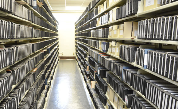 shelves full of video recordings in various formats in the Austin History Center archives
